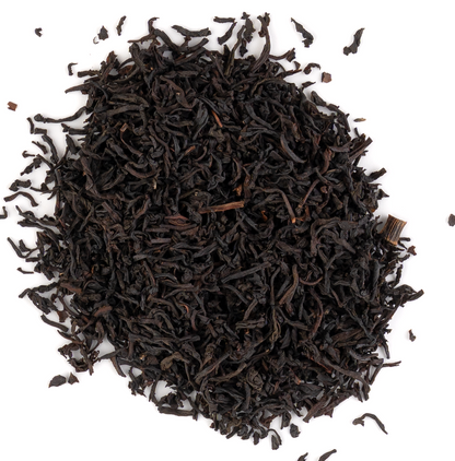 Creamy vanilla tea with loose black tea leaves and vanilla beans on a white background