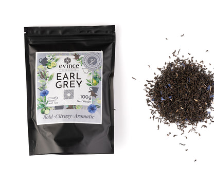Earl Grey tea with bergamot citrus slice, loose black tea leaves and its pack on a white background
