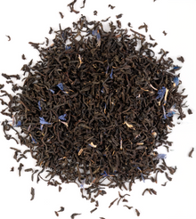 Earl Grey tea with bergamot citrus slice, loose black tea leaves on a white background