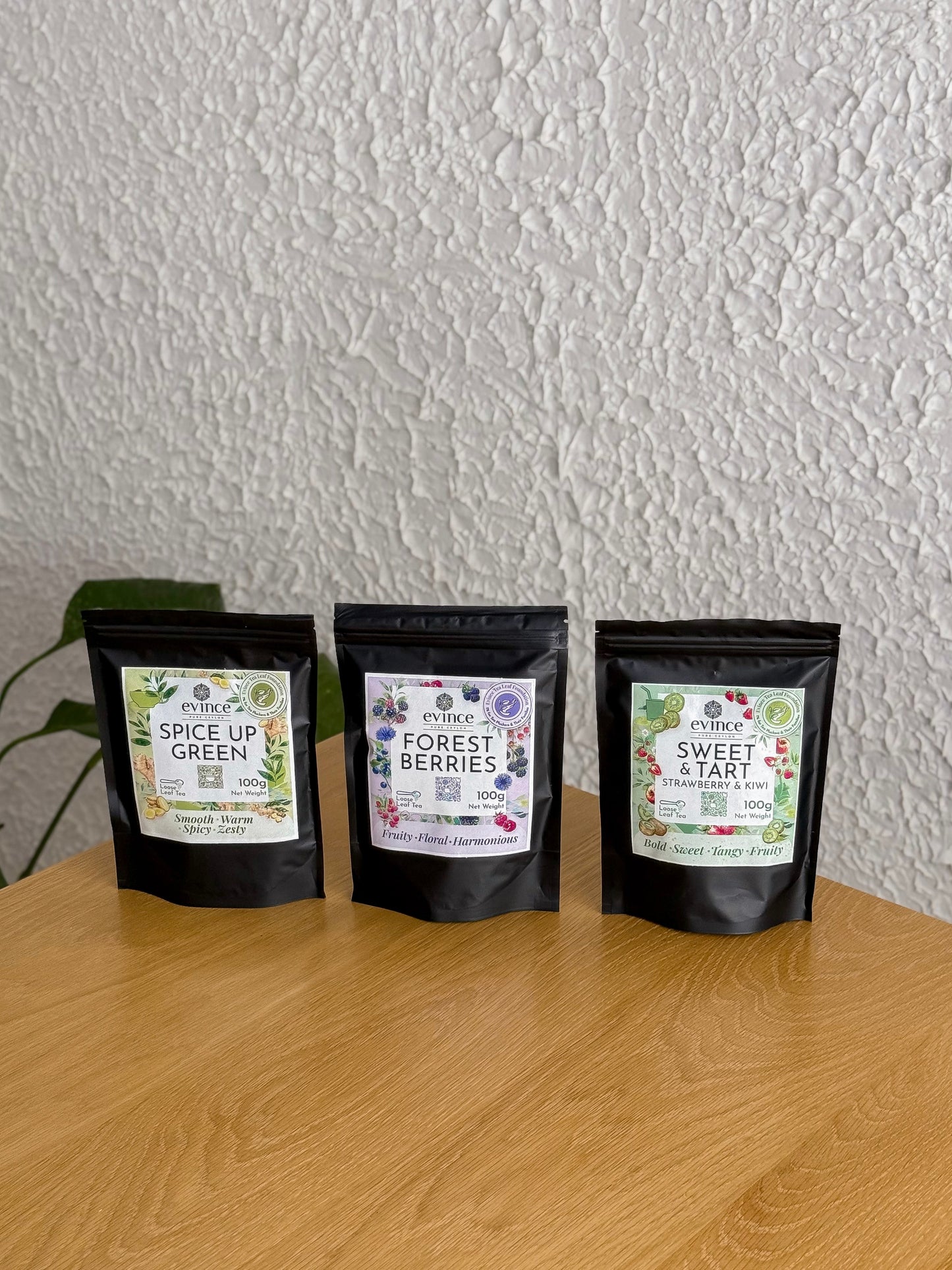 Evince fruity ceylon tea packs on a table against the white wall.